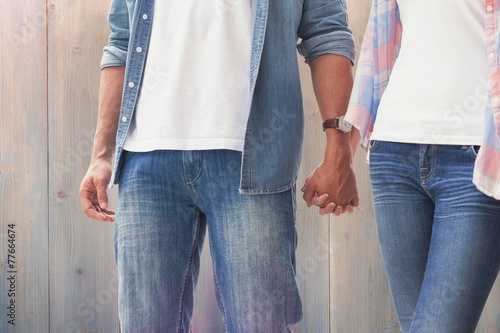 Composite image of hip young couple holding hands