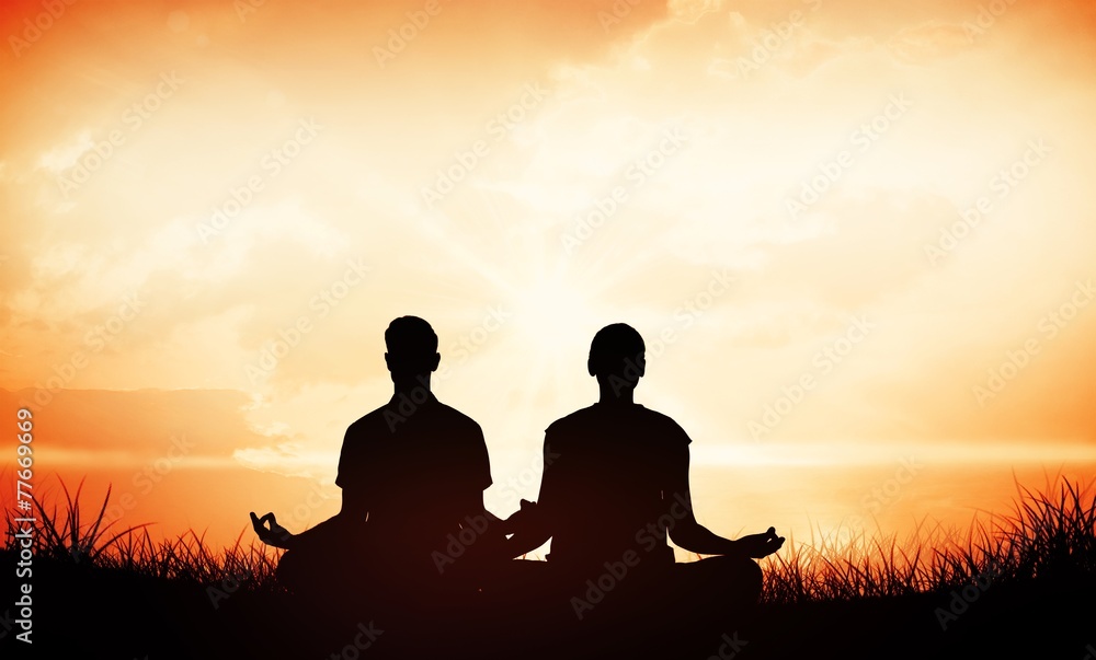 Attractive couple in white meditating in lotus