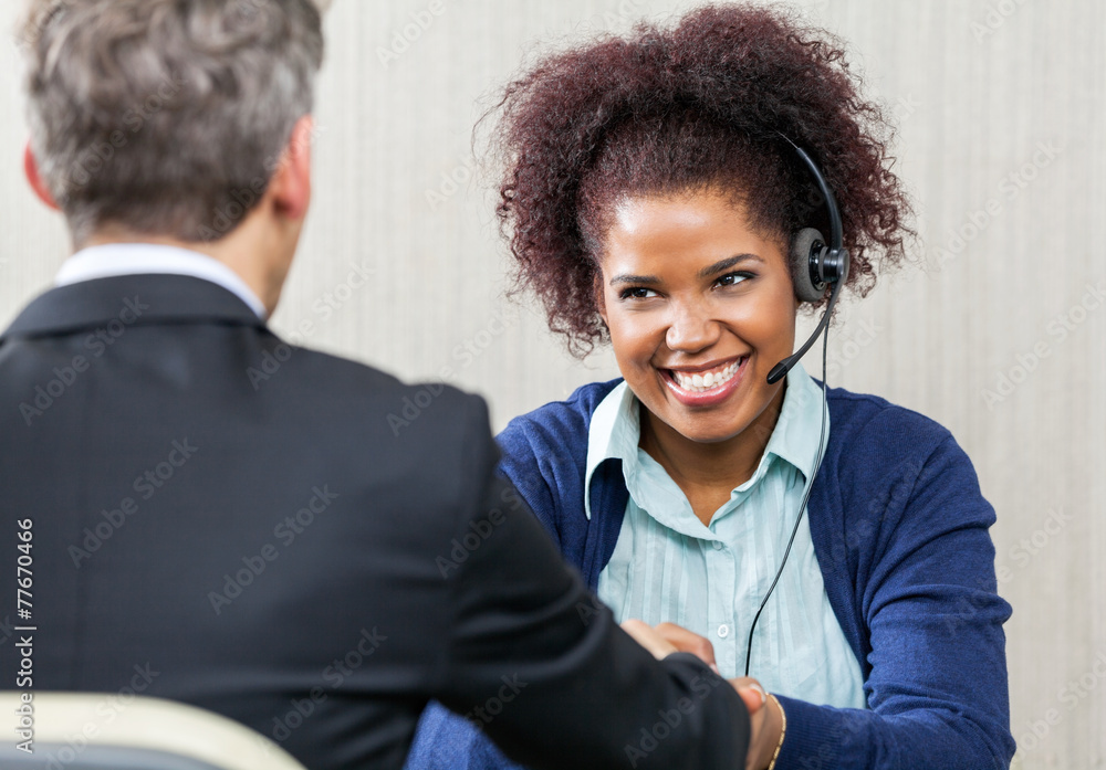 Obraz premium Happy Female Customer Service Agent Shaking Hands With Manager