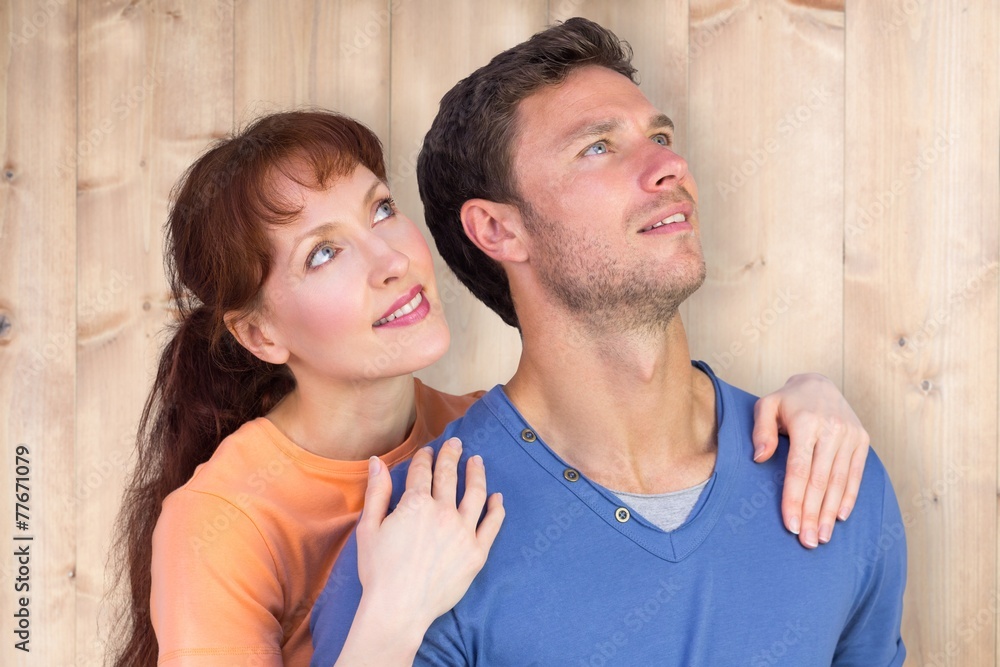 Composite image of happy couple looking upwards Composite image of happy couple looking upwards