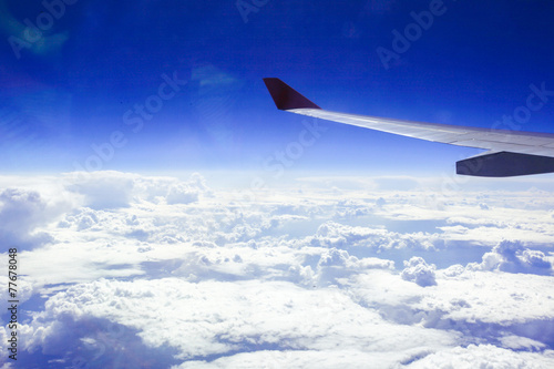Wing of an airplane in beautiful sky with clouds