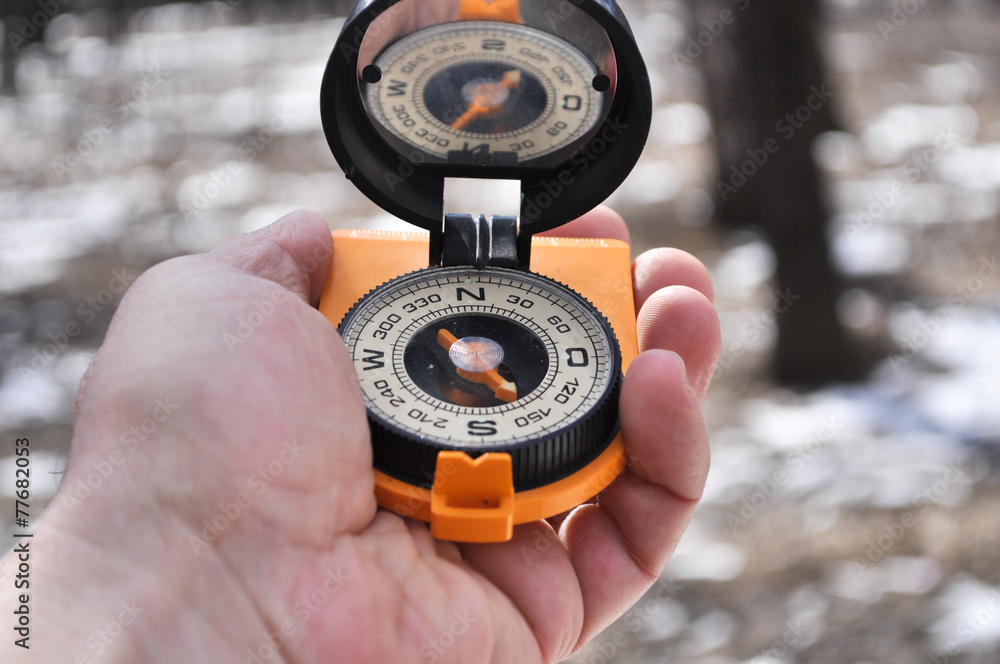 The compass in his hand outdoors. The compass in his hand outdoors.