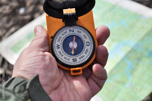 The compass in his hand outdoors.