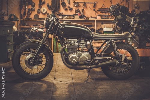 Vintage style cafe-racer motorcycle in customs garage