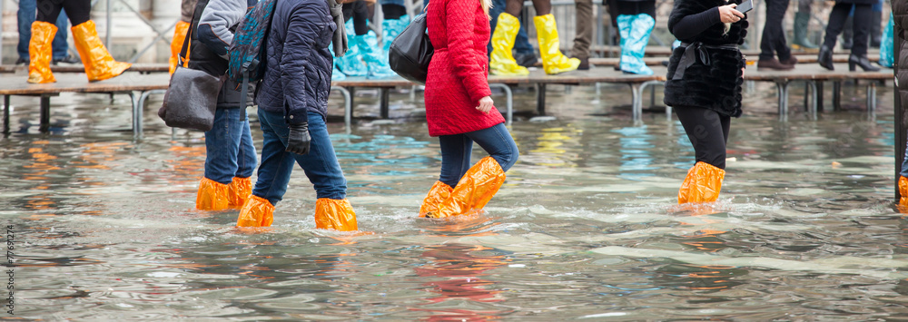 Obraz premium Zamknij Nogi z butami ze względu na wysoką wodę w Wenecji.