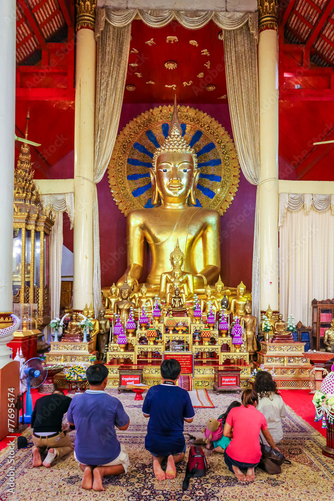 Famille priant dans un temple bouddhiste