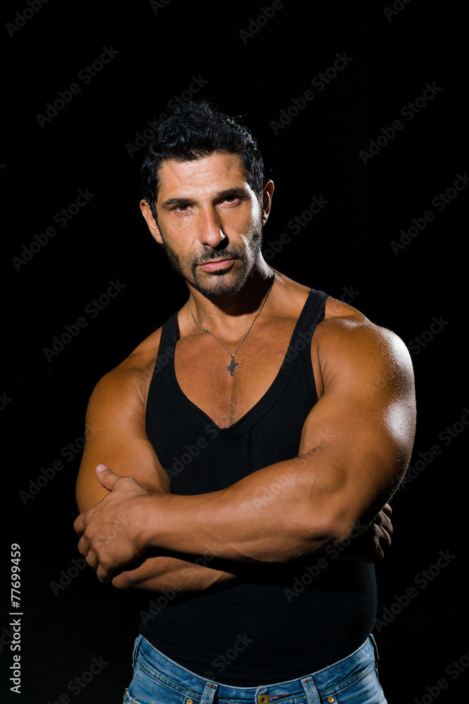 Handsome Muscled man in jeans over black background