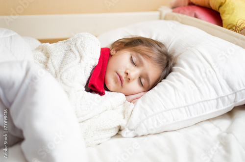 cute girl with cold sleeping under blanket