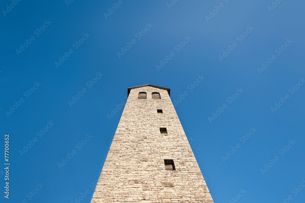 Ein eckiger Turm mit Satteldach unter blauem Himmel