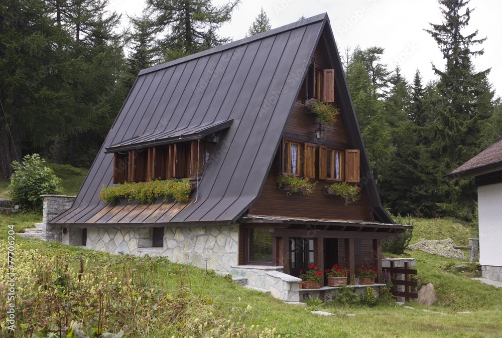Traditional mountain chalet in the summer season Traditional mountain chalet in the summer season