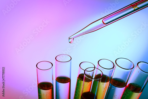 Pipette adding fluid to the one of test-tubes