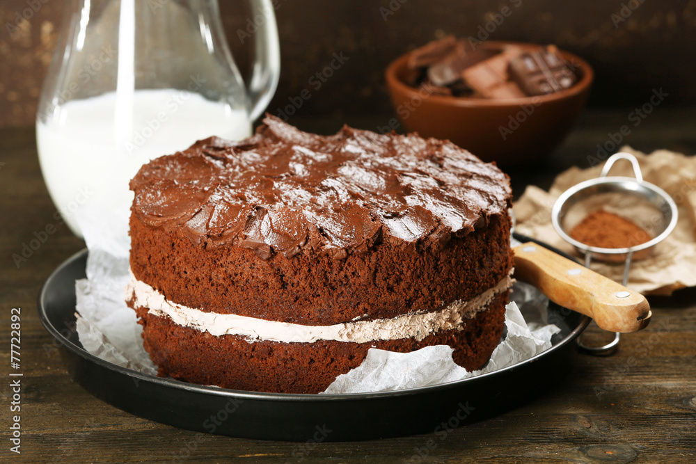 Delicious chocolate cake on table on brown background Delicious chocolate cake on table on brown background
