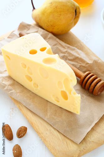 Cheese with almonds and pear on a cutting board