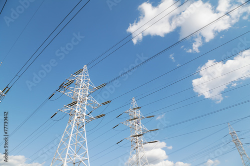 Power transmission lines against blue sky