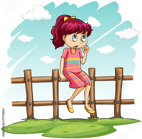 A girl sitting on the fence