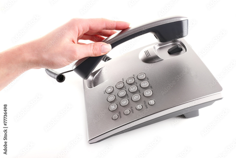 Female hand holding phone receiver isolated on white