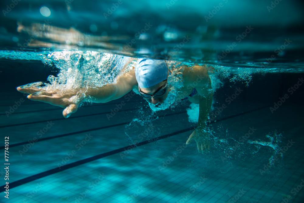 Male swimmer at the swimming pool.Underwater photo. - obrazy, fototapety, plakaty 