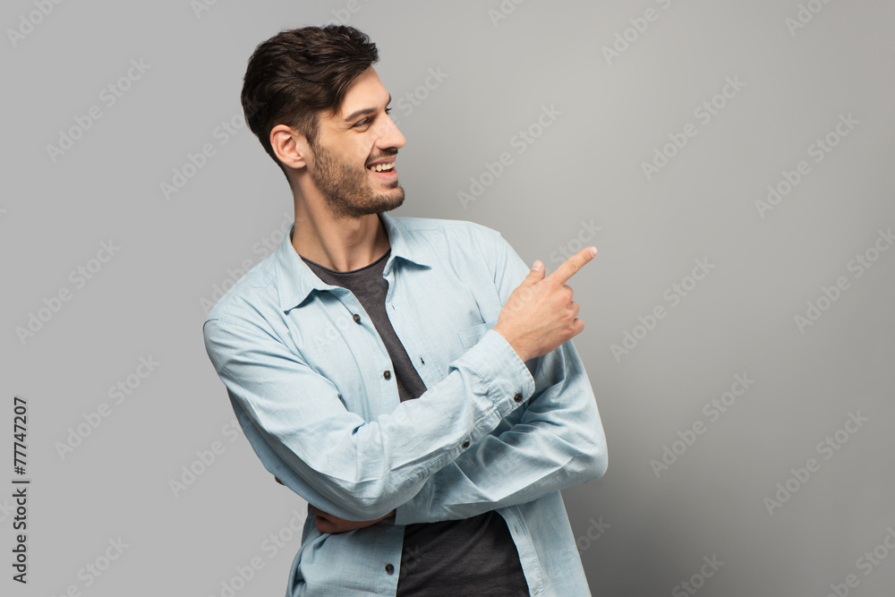 Smiling young man pointing at something Smiling young man pointing at something