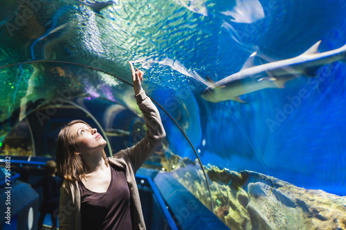 Young girl in aquarium tunnel with sharks