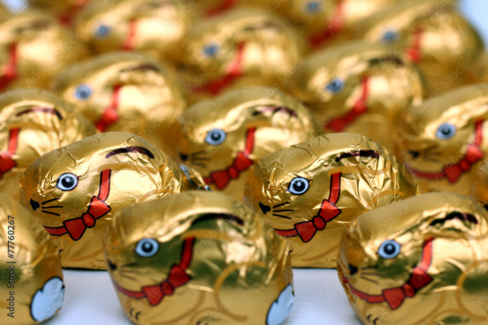 Viele goldene Schokoladenosterhasen m. Schleife