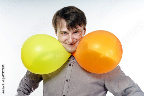 Young caucasian man holding yellow air balloons in his hand © 31etc