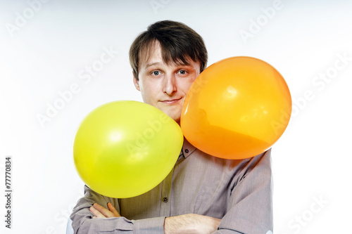 Young caucasian man holding yellow air balloons in his hand © 31etc