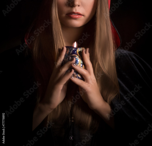 Beautiful woman with black cloak over black background