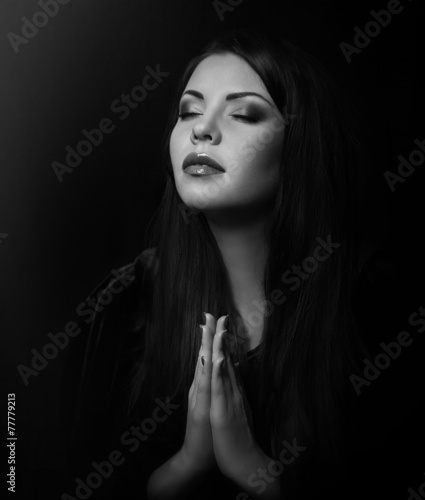 Beautiful woman with black cloak over black background