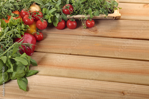 Herbs and vegetables with a blank wooden board for a copy space