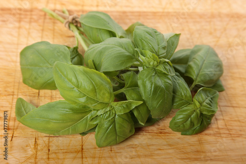 Bunch of fresh basil on an old wooden chopping board