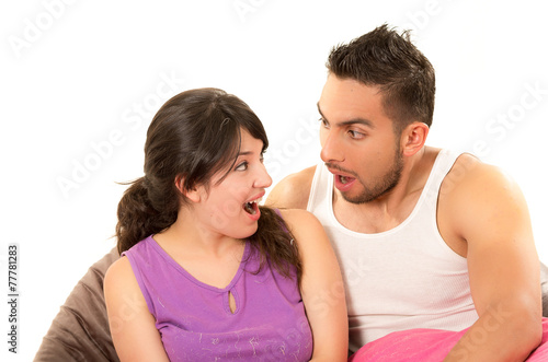 sweet latin couple looking at each other surprised wearing their