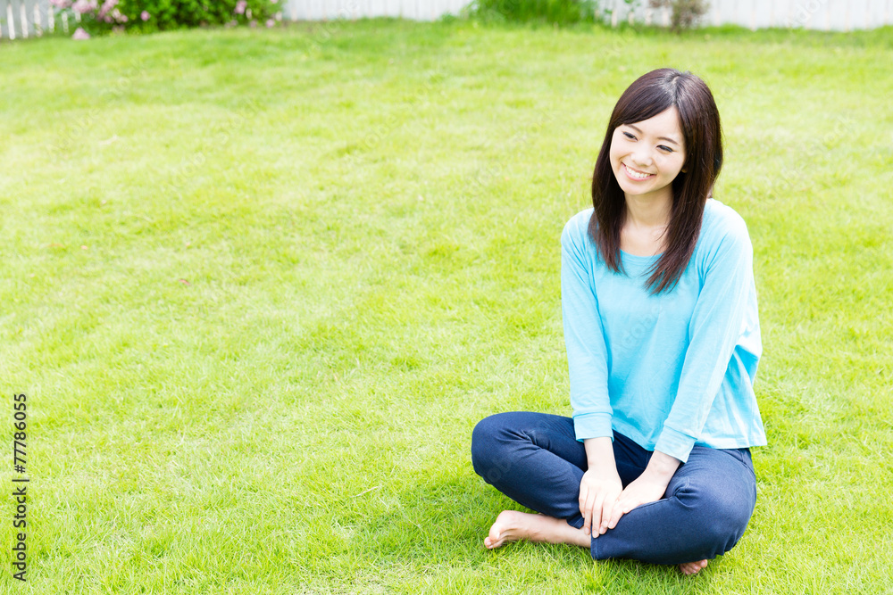 young asian woman relaxing on the lawn