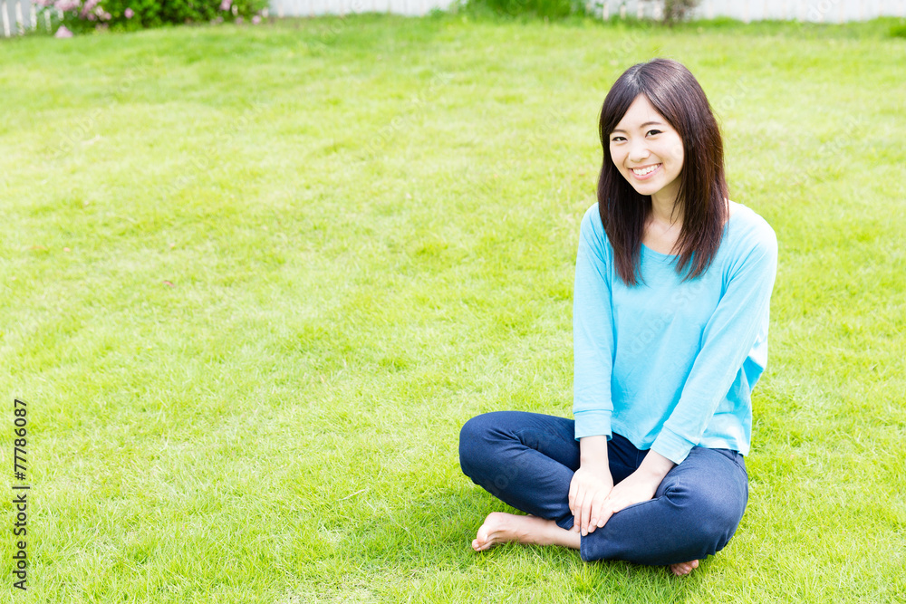 young asian woman relaxing on the lawn