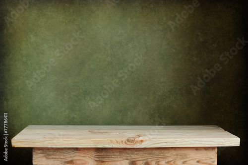 пустой деревянный стол на фоне зеленой стены
