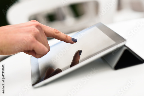 Woman's hand touching a tablet computer
