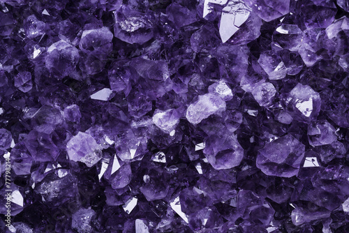 Dettaglio ravvicinato dei cristalli viola di un ametista gigante con qualche riflesso e luce piatta.