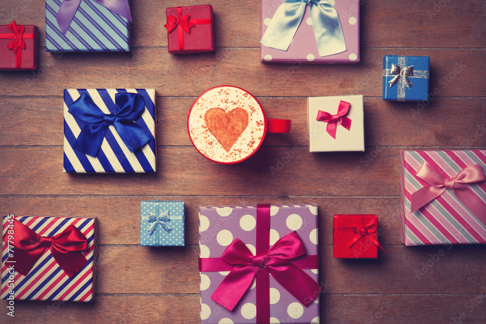 Fototapeta premium Cup and gift boxes on wooden background