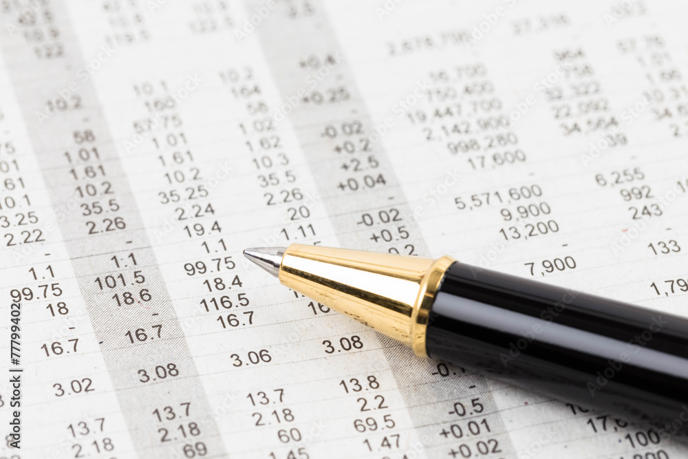 Pen rest on stock price detail financial newspaper Pen rest on stock price detail financial newspaper