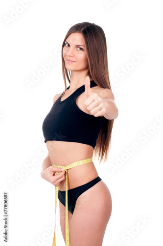 The woman measures the centimeter waist
