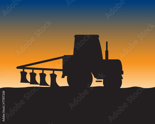 Silhouette of the tractor in field