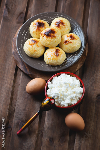 Curd pancakes and ingredients, rustic wooden background