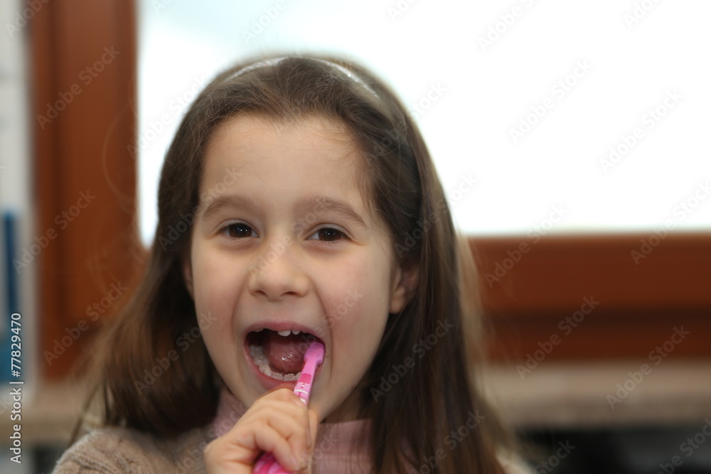 young girl without a tooth while brushing teeth in the bathroom young girl without a tooth while brushing teeth in the bathroom