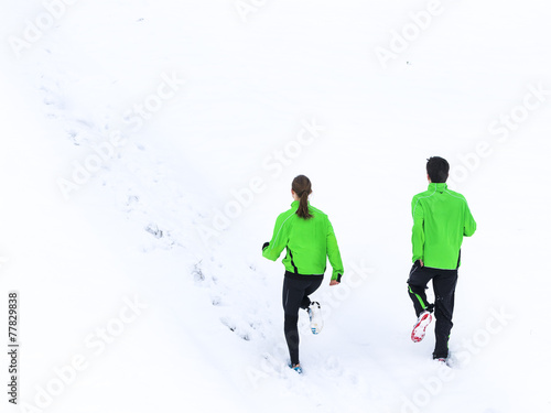 junger Mann und Frau joggen im Schnee