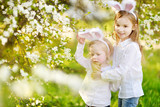 Two little sisters wearing bunny ears on Easter
