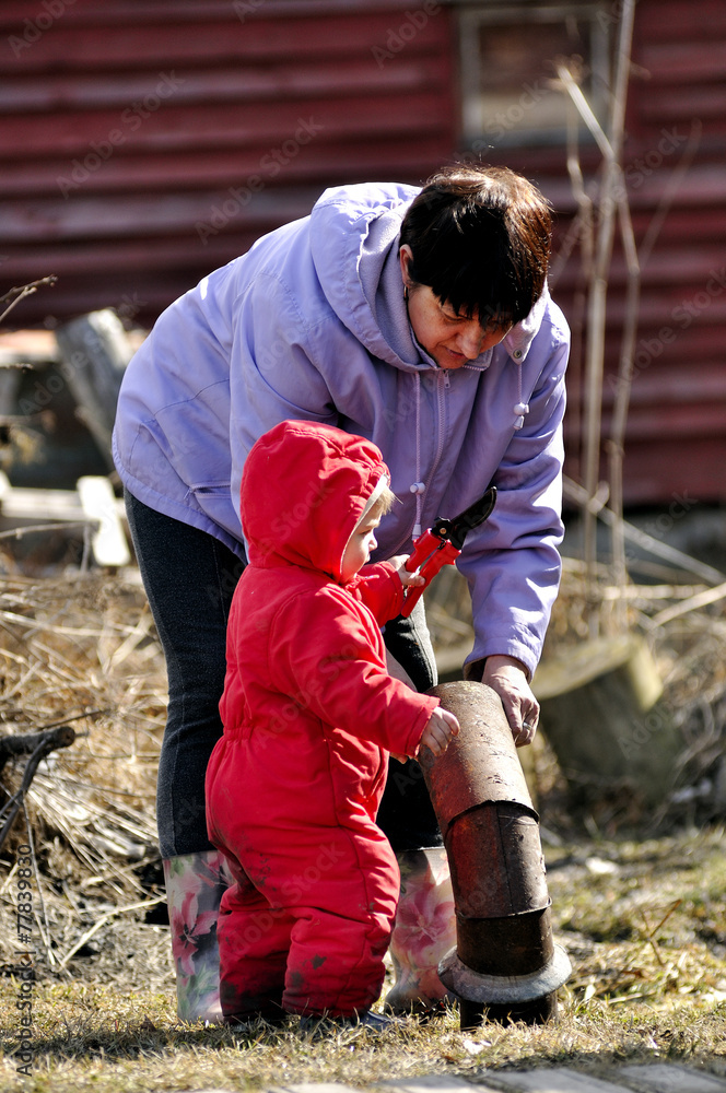 The grandmother and the grandson clean a site the village The grandmother and the grandson clean a site the village