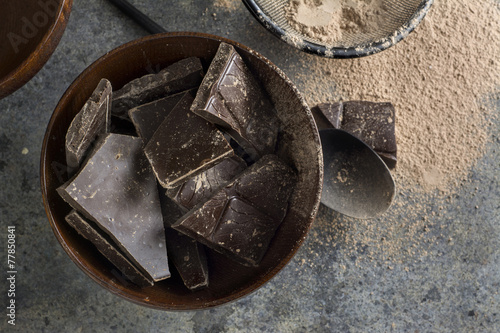 dark chocolate chunks in wooden bowl, on oak table
