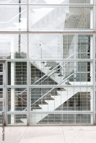 Interior of a modern glass building with stairs.