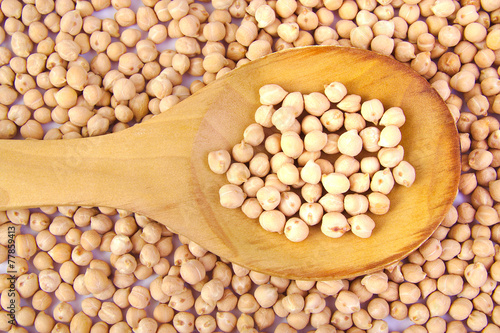 Uncooked chickpeas on wooden spoon photo