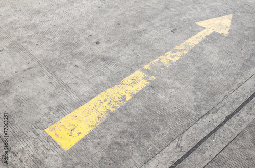 yellow way arrow pointing in directions symbol on a ground road © photoraidz