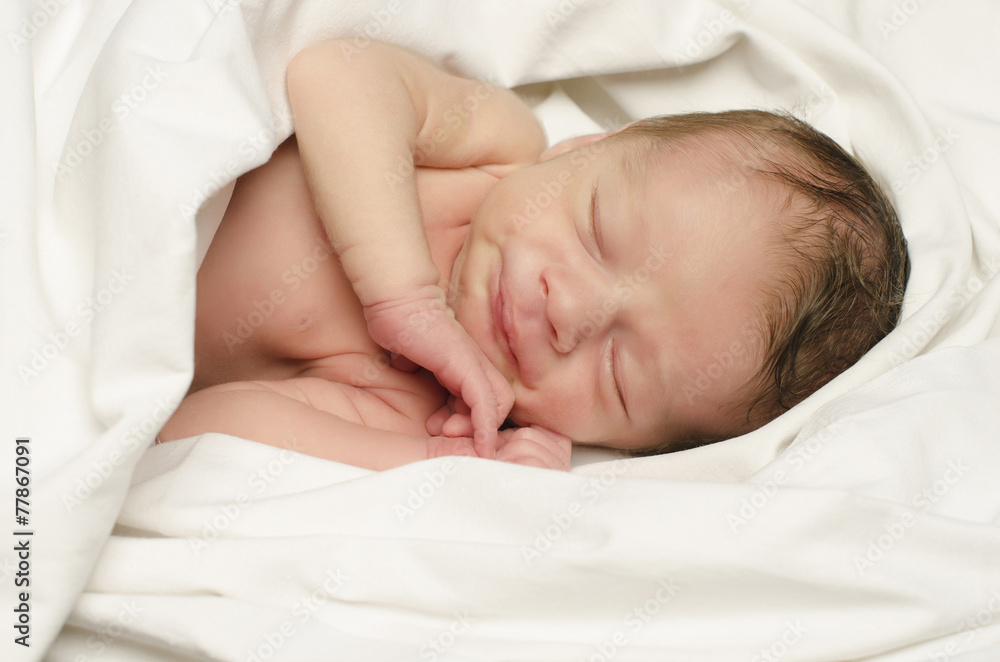Newborn baby boy smiling in his sleep happy during his nap. Newborn baby boy smiling in his sleep happy during his nap.